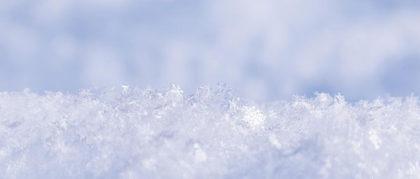 Background of fresh snow. Natural winter background. Snow texture in blue tone.