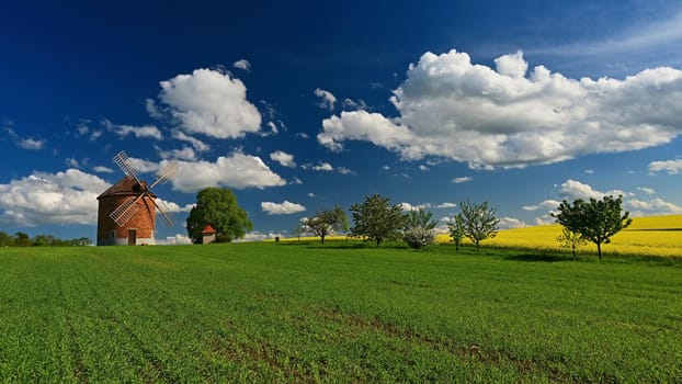 Beautiful spring landscape with blue sky, sun, clouds and old windmill.
Czech Republic Europe