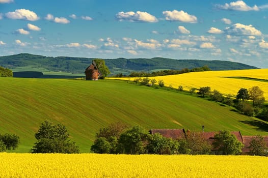 Beautiful spring landscape with blue sky, sun, clouds and old windmill.
Czech Republic Europe