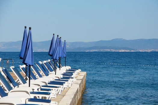 Rows of empty chaise-lounges over sea background, Supetar, Brac island, Croatia