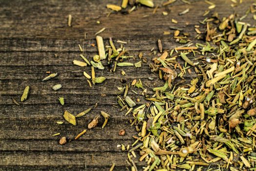 Dried thyme spilled on gray wooden board