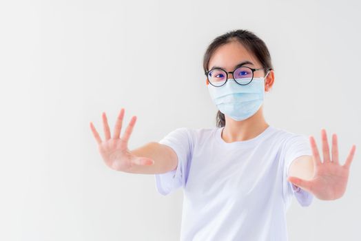 Portrait Asian young woman wears glasses and mask to protect against Coronavirus looking at camera, girl show hands stop coronavirus outbreak isolated on white background stop virus Covid 19 concept