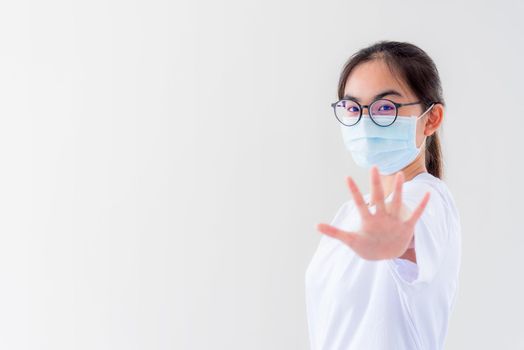 Portrait Asian young woman wears glasses and mask to protect against Coronavirus looking at camera, girl show hands stop coronavirus outbreak isolated on white background stop virus Covid 19 concept