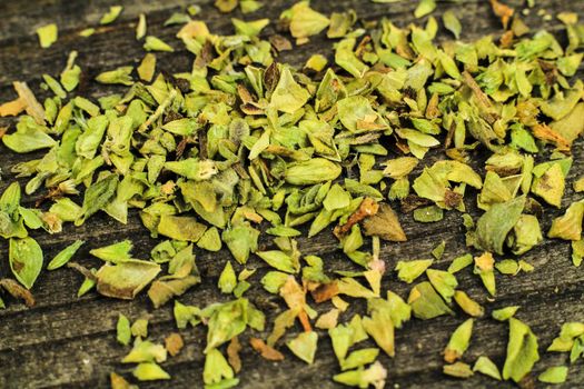 Crushed dried oregano to spice up dishes on gray wooden board