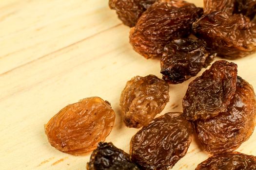 Tasty sultana raisins on brown wooden board