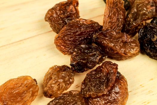 Tasty sultana raisins on brown wooden board