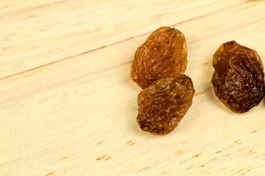 Tasty sultana raisins on brown wooden board