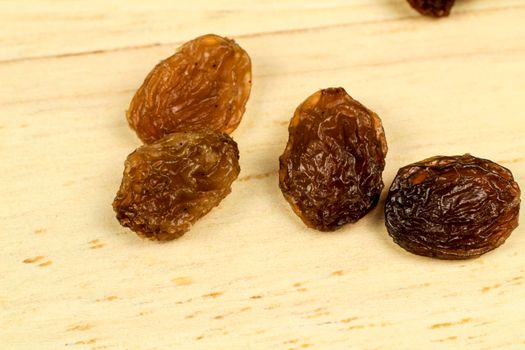 Tasty sultana raisins on brown wooden board