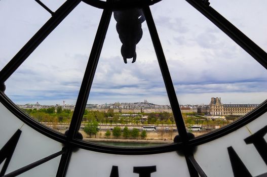 Paris cityscape, skyline view through the famous clock in the Orsay Museum. France. April 2019