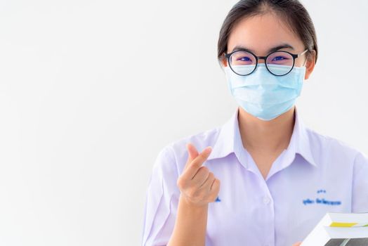 Student Asian young woman wear a mask to protect Coronavirus, Girl to encourage show two fingers mini heart symbol love to fight and strong on white background health care from Covid 19 virus outbreak