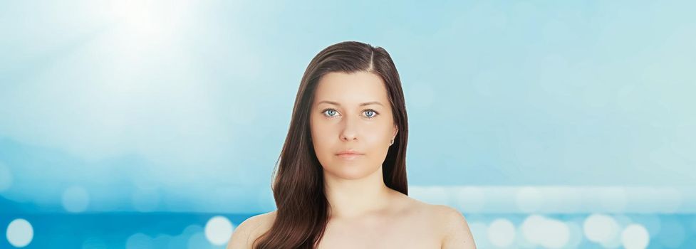 Skincare and sun protection in summer. Portrait of a beautiful young suntanned woman, blue sea and sky on background, beauty, wellness and travel concept.