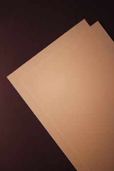 Blank A4 paper, beige on dark background as office stationery flatlay, luxury branding flat lay and brand identity design for mockups