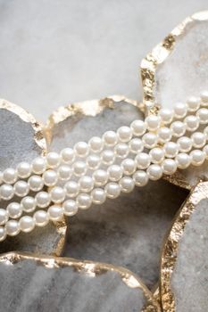 Pearl necklace on golden marble, ethical jewellery - luxury background, jewelry as a gift concept. Pearls are girl's best friends