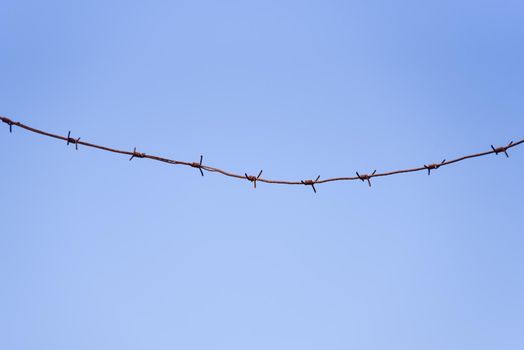 barbed wire against a blue sky background.