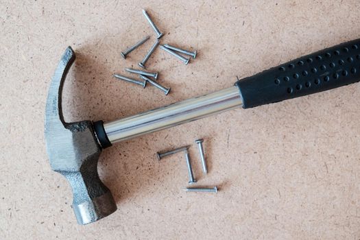 Iron hammer and nails on plywood. wood background.