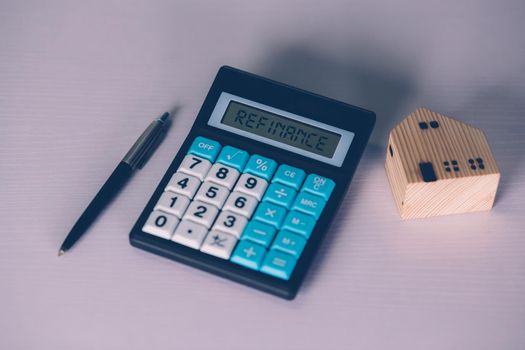 Calculator with text refinance home while expense for loan mortgage, investment and banking, property and cost, real estate and transfer for debt, planning and management of finance, business concept.