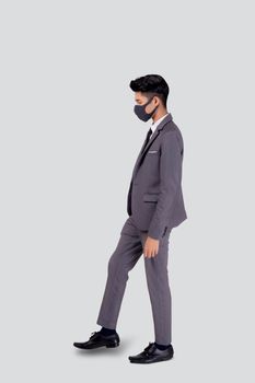 Portrait young asian businessman in suit wearing face mask walk step for protective covid-19 isolated on white background, business man and healthcare, quarantine for pandemic coronavirus, new normal.