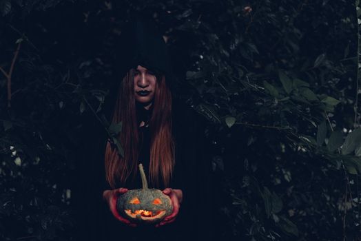 Portrait woman scary ghost in forest he has holding pumpkin dark tone, halloween concept