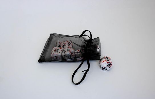 Black transparent pouch and dice isolated on white background.Flying dice.