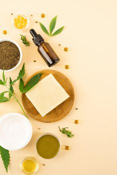 Alternative medicine, natural cosmetics. cbd oil and cannabis leaves cosmetics top view on orange background, flat lay