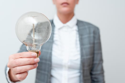 Lady Holding Lamp With Formal Outfit Presenting New Ideas For Project, Business Woman Showing Bulb With One Hand Exhibiting New Technologies, Lightbulb Presenting Another Openion.