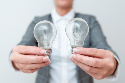 Lady Carrying Two Lightbulbs In Hands With Formal Outfit Presenting Another Ideas For Project, Business Woman Holding 2 Lamps Showing Late Technologies, Lighbulb Exhibiting Fresh Openion.