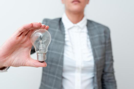 Lady Holding Lamp With Formal Outfit Presenting New Ideas For Project, Business Woman Showing Bulb With One Hand Exhibiting New Technologies, Lightbulb Presenting Another Openion.
