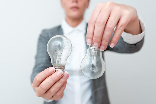 Lady Holding Two Lamps Upside Down With Outfit Proposing New Ideas For Project, Business Woman Carry 2 Bulbs Opposite Displaying New Technologies, Two Vise Versa Lamps Exhibiting Fresh Idea.