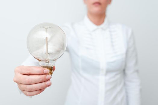 Lady Holding Lamp With Formal Outfit Presenting New Ideas For Project, Business Woman Showing Bulb With One Hand Exhibiting New Technologies, Lightbulb Presenting Another Openion.