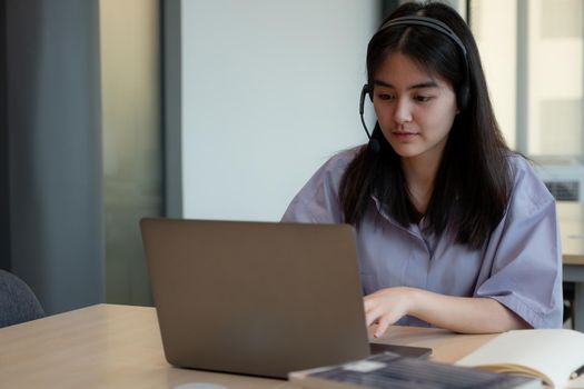 asian girl in headphones have video call distant class with teacher using laptop, young student wearing headphone with tutor, study online on computer, homeschooling concept