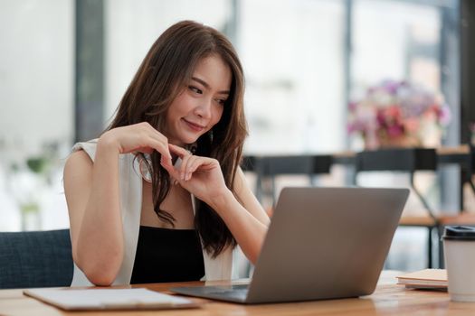 Portrait of attractive asian business woman working with laptop computer for group online meeting conference.