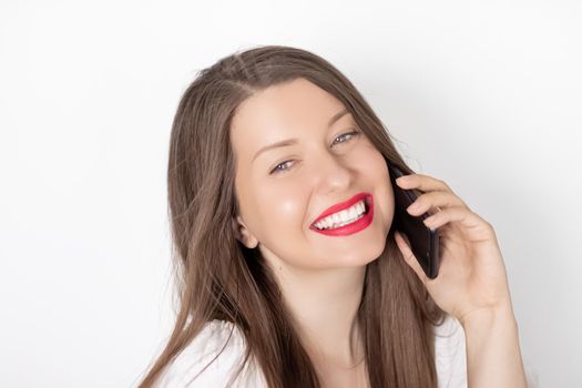 Happy smiling woman calling on smartphone, portrait on white background. People, technology and communication concept.