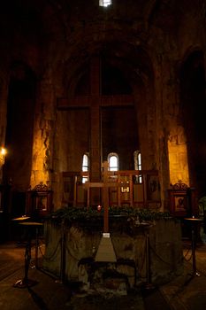 Dark temple with small windows and burning candles.