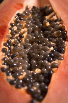 Half of an open papaya with the seeds. No people