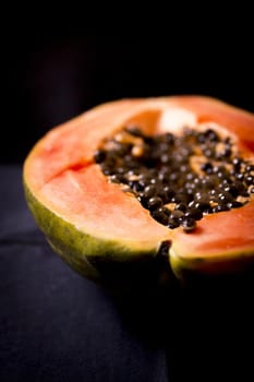 Half of an open papaya with the seeds. No people