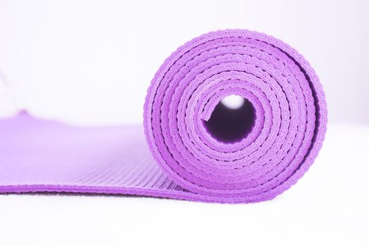 Rolled up yoga or pilates mat. No people
