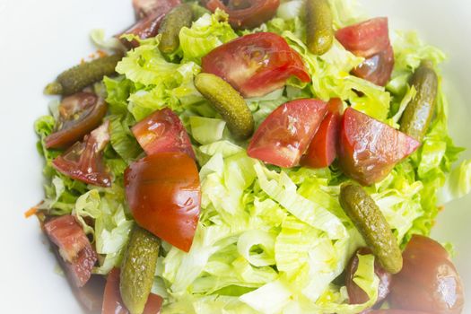 Lettuce salad with tomato and pickles. Raw food