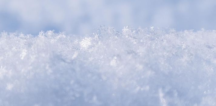 Background of fresh snow. Natural winter background. Snow texture in blue tone.