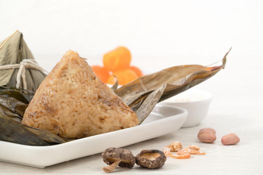 Zongzi. Rice dumpling for Chinese traditional Dragon Boat Festival (Duanwu Festival) on bright wooden table background with ingredient.