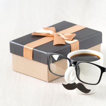 Father's day design concept. Close up of cup of coffee and gift box for daddy funny idea.
