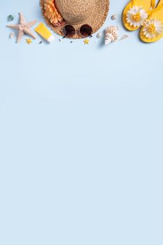 Summer beach background design concept. Top view of holiday travel with shells, hat, slipper on blue background.