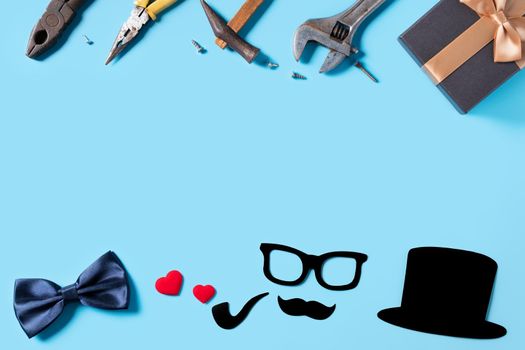 Father's day background design concept. Top view of color paper decoration layout ideas and working tool on blue table background with copy space.