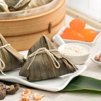 Zongzi. Rice dumpling for Chinese traditional Dragon Boat Festival (Duanwu Festival) on bright wooden table background with window.