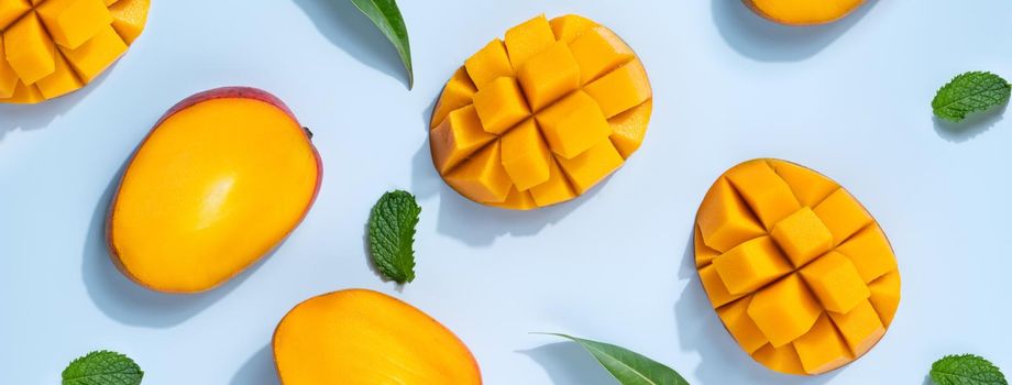 Mango design concept. Top view of diced fresh mango fruit pattern on blue table background.