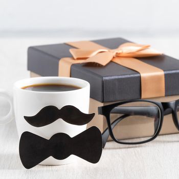 Father's day design concept. Close up of cup of coffee and gift box for daddy funny idea.