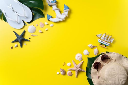 Summer beach design concept. Top view of holiday travel with shells, hat, slipper on yellow background.