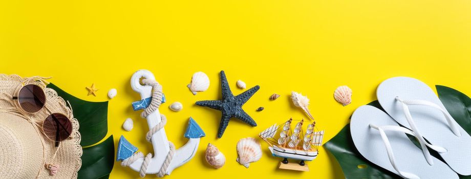 Summer beach design concept. Top view of holiday travel with shells, hat, slipper on yellow background.