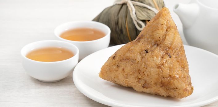 Zongzi. Rice dumpling for Chinese traditional Dragon Boat Festival (Duanwu Festival)  on bright wooden table background.