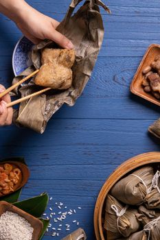 Zongzi rice dumpling with ingredients top view for Chinese traditional Dragon Boat Festival (Duanwu Festival) over blue wooden table background.