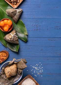 Zongzi rice dumpling with ingredients top view for Chinese traditional Dragon Boat Festival (Duanwu Festival) over blue wooden table background.